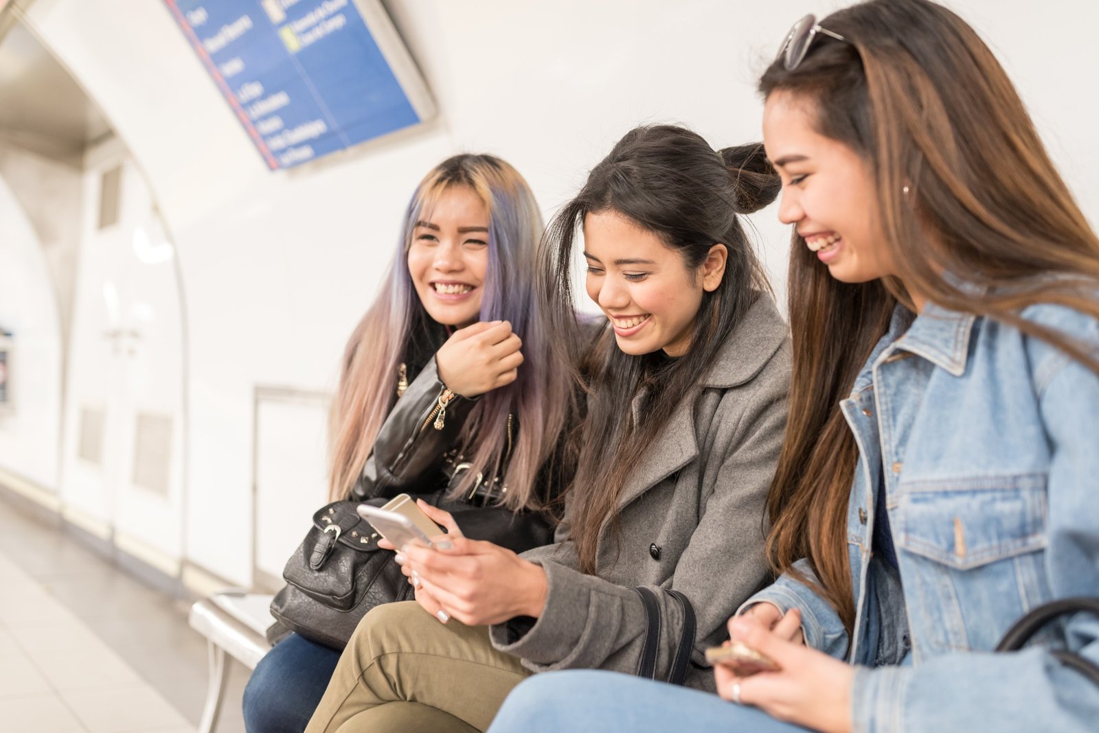 philippine friends women in metro station with the mobile phone smiling in Madrid